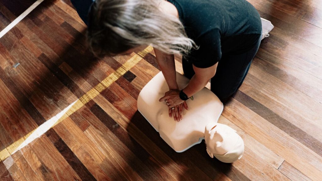 The Art of Drawing Readers In: Your attractive post title goes here A person practices CPR on a training mannequin indoors.